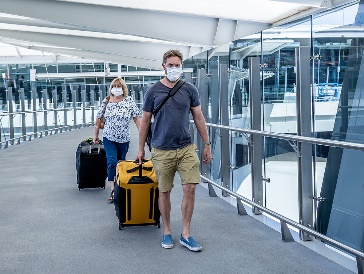 2 people with suitcases at an airport.