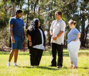 A group of people having a conversation in a park.