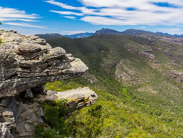 A rocky outcrop overlooking a vast mountain range.