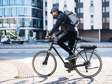 A person riding a bicycle through a public space.