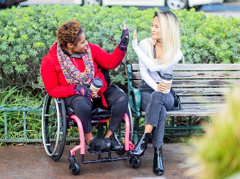 2 people in a park giving each other a high five.