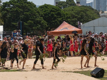 A large group of people attending a cultural event in a public space.