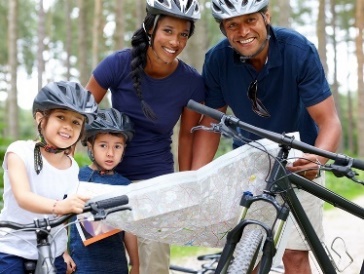 A family riding bikes in a park.