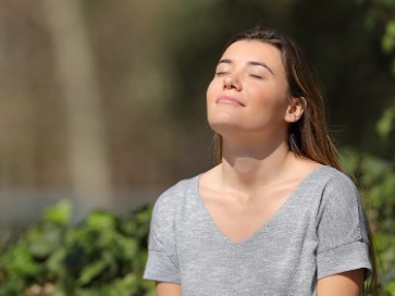 A person with a relaxed expression in a park.