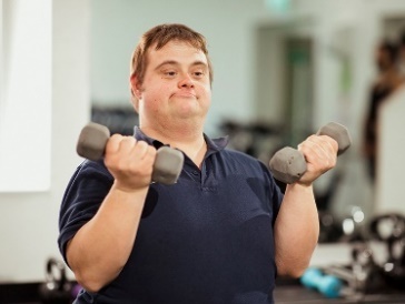 A person lifting barbell weights in a gym.